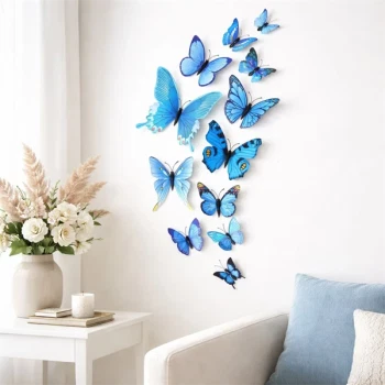 Blå 3D sommerfugle vægdekoration monteret på hvid væg over sofa i lys stue med foldbare vinger og naturtro dybde