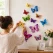 Person sætter 3D sommerfugle farvemix med dobbeltvinger op på væg som farverig vægdekoration