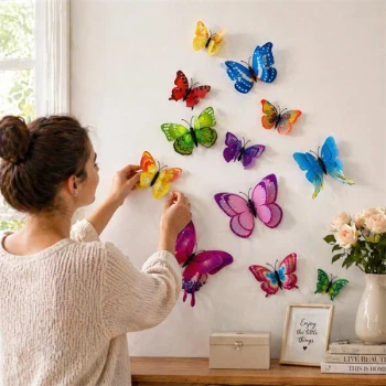Person sætter 3D sommerfugle farvemix med dobbeltvinger op på væg som farverig vægdekoration