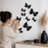 Person sætter 3D sorte sommerfugle wallstickers op på væg som moderne vægdekoration