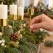 Advent lysholder på spyd i guld monteres i adventsdekoration med gran og mos