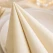 Close-up af creme Airlaid serviet med stoflignende struktur og dekorativ foldning