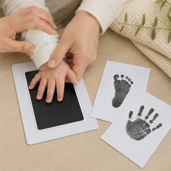 Forælder laver håndaftryk med baby hånd og fod aftrykssæt ved hjælp af Clean Touch-teknologi uden blæk på babys hud.