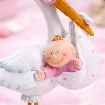 Close-up af stork med baby pige i lyserød – detaljeret barnedåbspynt til baby shower og borddekoration