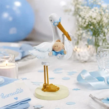 Stork med baby dreng som bordpynt til barnedåb med blå dekoration og borddækning