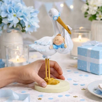 Stork med baby dreng som bordpynt til barnedåb i blå tema placeret på festbord
