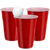 Tre røde beer pong plastikkopper med en hvid bold foran på hvid baggrund