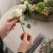 Person bruger blomsterpind i metal 1,20 mm x 30 cm til blomsterbinding af en hvid rose. Ideel til blomsterdekorationer, kranse og kreative hobbyprojekter.