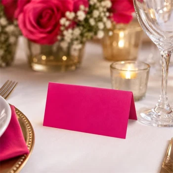 Cerise tekstureret bordkort ved elegant borddækning med blomster, stearinlys og vinglas