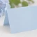 Close-up af lyseblåt tekstureret bordkort 10x7 cm med synlig papirstruktur til bryllup, barnedåb og konfirmation