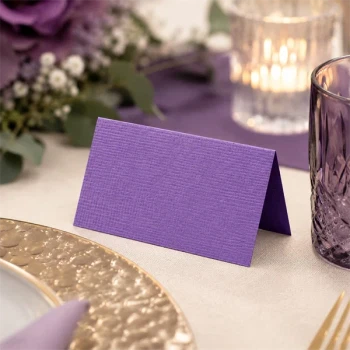 Lilla tekstureret bordkort i elegant borddækning med blomster lys og glas til bryllup eller konfirmation