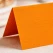 Close-up af orange tekstureret bordkort 10x7 cm med synlig papirstruktur