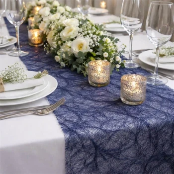 Elegant festbord pyntet med mørk blå Sizoweb bordløber, hvide blomster og levende lys til bryllup og fest