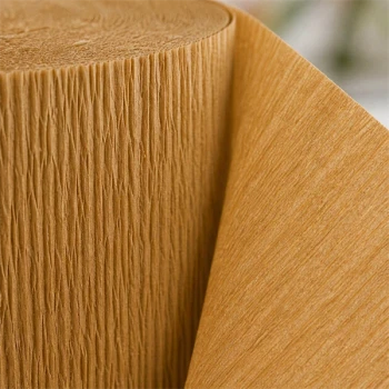 Close-up af guld crepepapir struktur på rulle med detaljeret tekstur og fleksibelt papir til fest