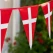 Close-up af Dannebrog flagguirlande i plast med røde og hvide vimpelflag