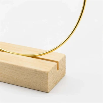 Close-up af dekorationsring 20 cm guld med træfod i naturtræ til borddekoration