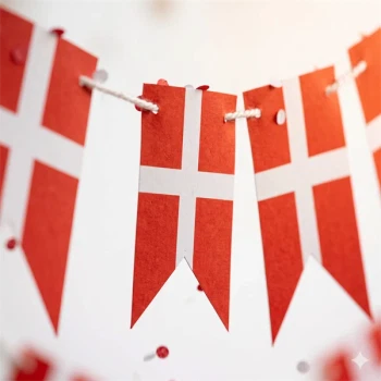 Nærbillede af detaljer på en traditionel Dannebrog flagguirlande i papir med hvid snor.