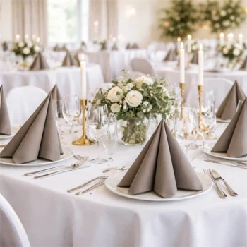 Pyntet festlokale med runde borde dækket med gråbrune Sovie Linclass airlaid servietter og blomsterdekorationer