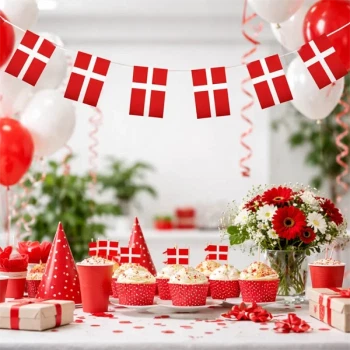 Flag guirlande med Dannebrog hængt over festbord med cupcakes og dekoration til fødselsdag