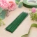 Grønne blomsterpinde i metal til blomsterbinding og papirblomster omgivet af blomster og floristmaterialer
