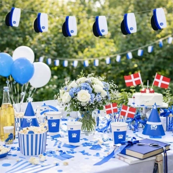Studenterfest med guirlande af blå studenterhuer, pyntet festbord i blå og hvide farver samt danske flag.