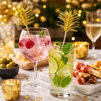 Cocktails med guld folie drinks pyntepinde på festligt bord med lys og snacks