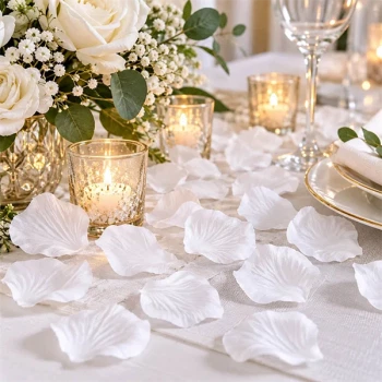 Hvide rosenblade som romantisk bordpynt på elegant bryllupsbord med blomster og lys
