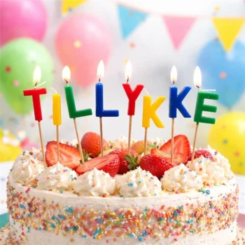 Kagelys TILLYKKE bogstaver på fødselsdagskage med jordbær, flødeskum og krymmel