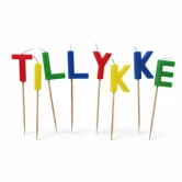 Kagelys TILLYKKE bogstaver i farver med træpinde på hvid baggrund