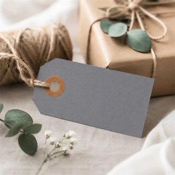 Gråt manillamærke 4x8 cm med jutesnor ved gaveindpakning med naturmaterialer og eucalyptus.