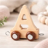 Navnetog bogstav Å i naturtræ på træbord i lyst børneværelse med bløde naturfarver