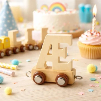 Naturfarvet navnetog bogstav Æ i træ som dekoration på bord til børnefødselsdag med kage, cupcake og festpynt