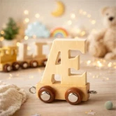 Naturfarvet navnetog bogstav Æ i træ på bord pyntet til børnefødselsdag med kage, cupcakes og festpynt i baggrunden