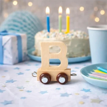 Navnetog bogstav B i naturtræ som togvogn på pyntet fødselsdagsbord med kage og lys