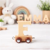 Navnetog bogstav F i naturtræ som trælegetøj på børneværelse med bamse, regnbue og plante i baggrunden