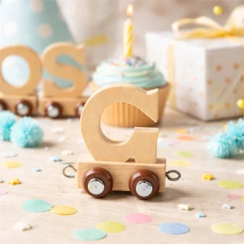 Navnetog bogstav G i naturtræ på festbord med cupcake, lys og pynt til børnefødselsdag