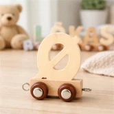 Naturfarvet navnetog bogstav Ø i træ på bord pyntet til børnefødselsdag med cupcakes og farverig dekoration