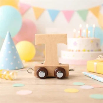 Navnetog bogstav T i naturtræ som dekoration på bord til børnefødselsdag med kage, balloner og pynt
