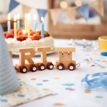 Navnetog i naturtræ på fødselsdagsbord med kage og lys