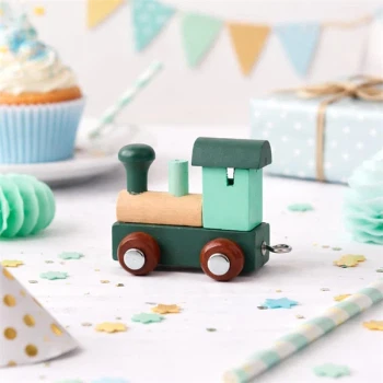 Arktisk blåt navnetog lokomotiv i træ på pyntet fødselsdagsbord med gave og cupcakes