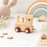 Navnetog lokomotiv i naturtræ på børneværelse med bløde naturfarver og trælegetøj