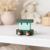 Navnetog togvogn i arktisk blå på hylde i lyst børneværelse med blød nordisk indretning