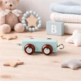 Arktisk blå navnetog trailer i træ på bord i børneværelse omgivet af bamse, trælegetøj og bløde tekstiler