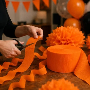 Brugsbillede af orange crepepapir på rulle brugt til DIY pynt, guirlander og festdekorationer til Halloween og fødselsdag