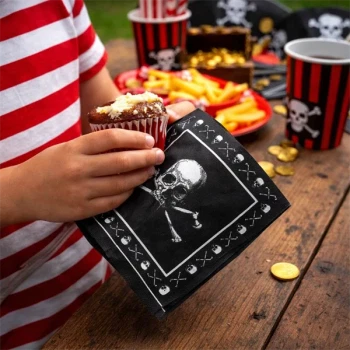 Barn holder cupcake med pirat serviet med dødningehoved til pirat fødselsdag og borddækning