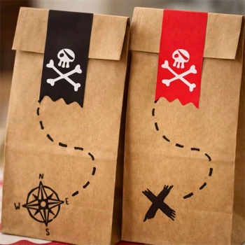 Close-up af pirat slikposer i papir med dødningehoved og skattekort design til børnefødselsdag