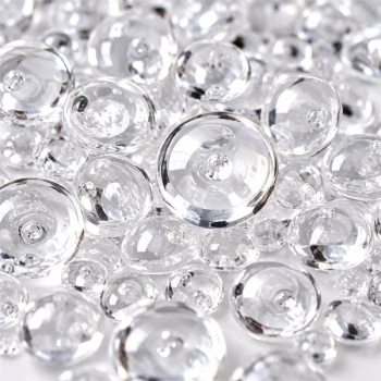 Nærbillede af klare Raindrops dekorationsdråber med blanke overflader, transparente detaljer og flotte lysrefleksioner.Klare Raindrops dekorationsdråber fra Eurosand i farven Natural, vist som en bunke transparente, glinsende dråber på hvid baggrund.