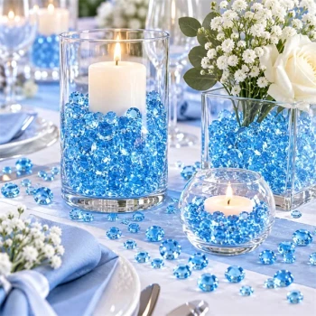 Lyseblå Raindrops dekorationsdråber i glasvaser med hvide blomster og levende lys på et elegant festbord med blå bordpynt.