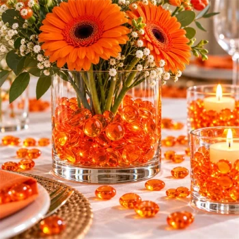 Raindrops Orange dekorationsdråber i glasvase med orange gerberaer og hvide blomster på et festligt dækket bord.