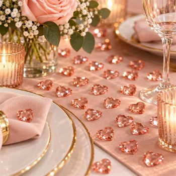 Rosa guld hjerter som bordpynt med blomster, lys og rosa servietter
